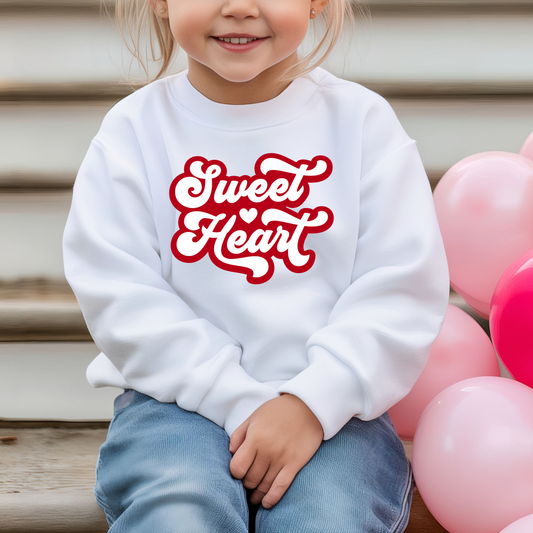 Front view of a kid wearing a white sweatshirt with Red Sweetheart on the front.
