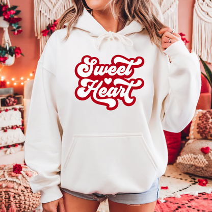 Front view of a girl wearing a white hoodie with sweet heart written in Red letters