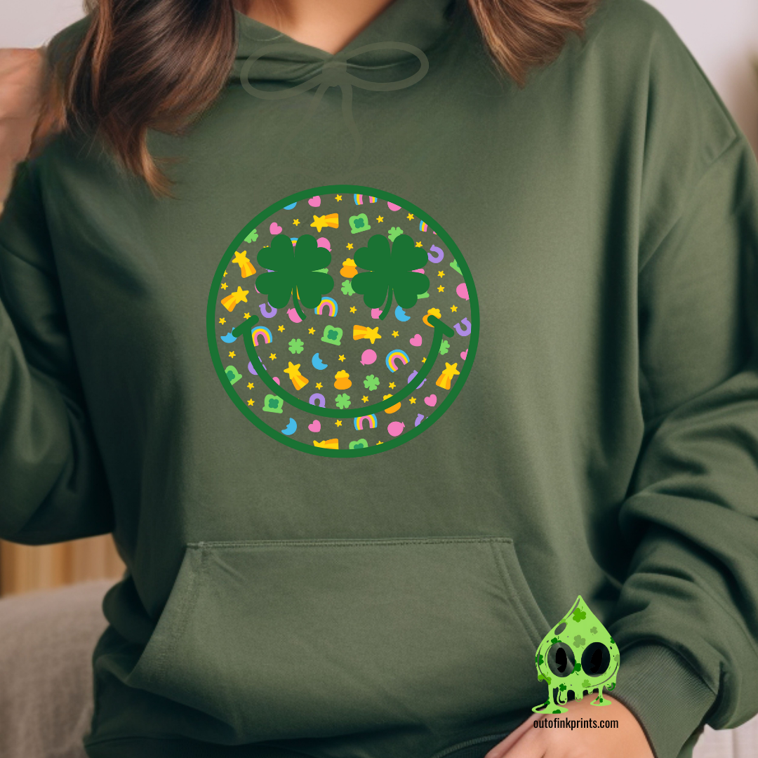 Front view of a dark green hoodie with a graphic of a smiley face made from clovers and St. Patrick's Day-themed elements.