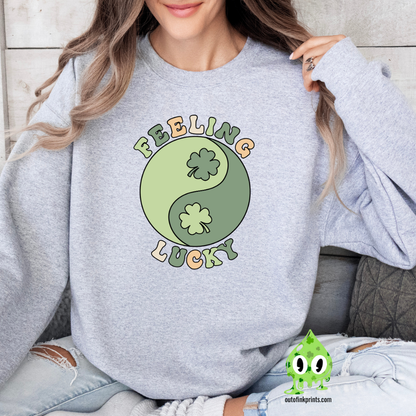 A woman wearing a grey sweatshirt with 'Feeling Lucky Yin & Yang' text and a four-leaf clover, in a yin and yang design.