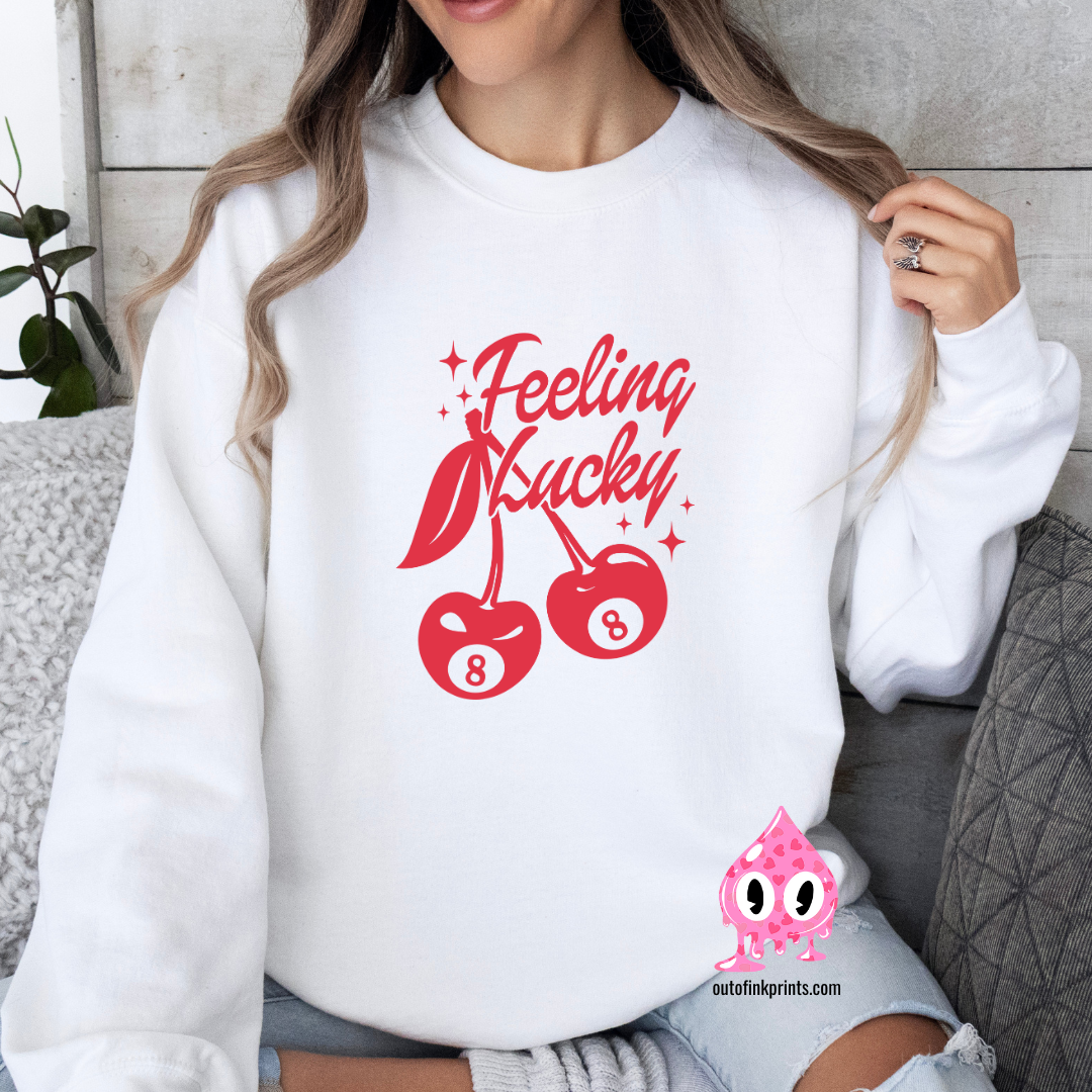 Front view of a white sweatshirt with a red 'Feeling Lucky' text and cherry graphics