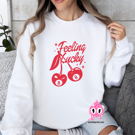 Front view of a white sweatshirt with a red 'Feeling Lucky' text and cherry graphics