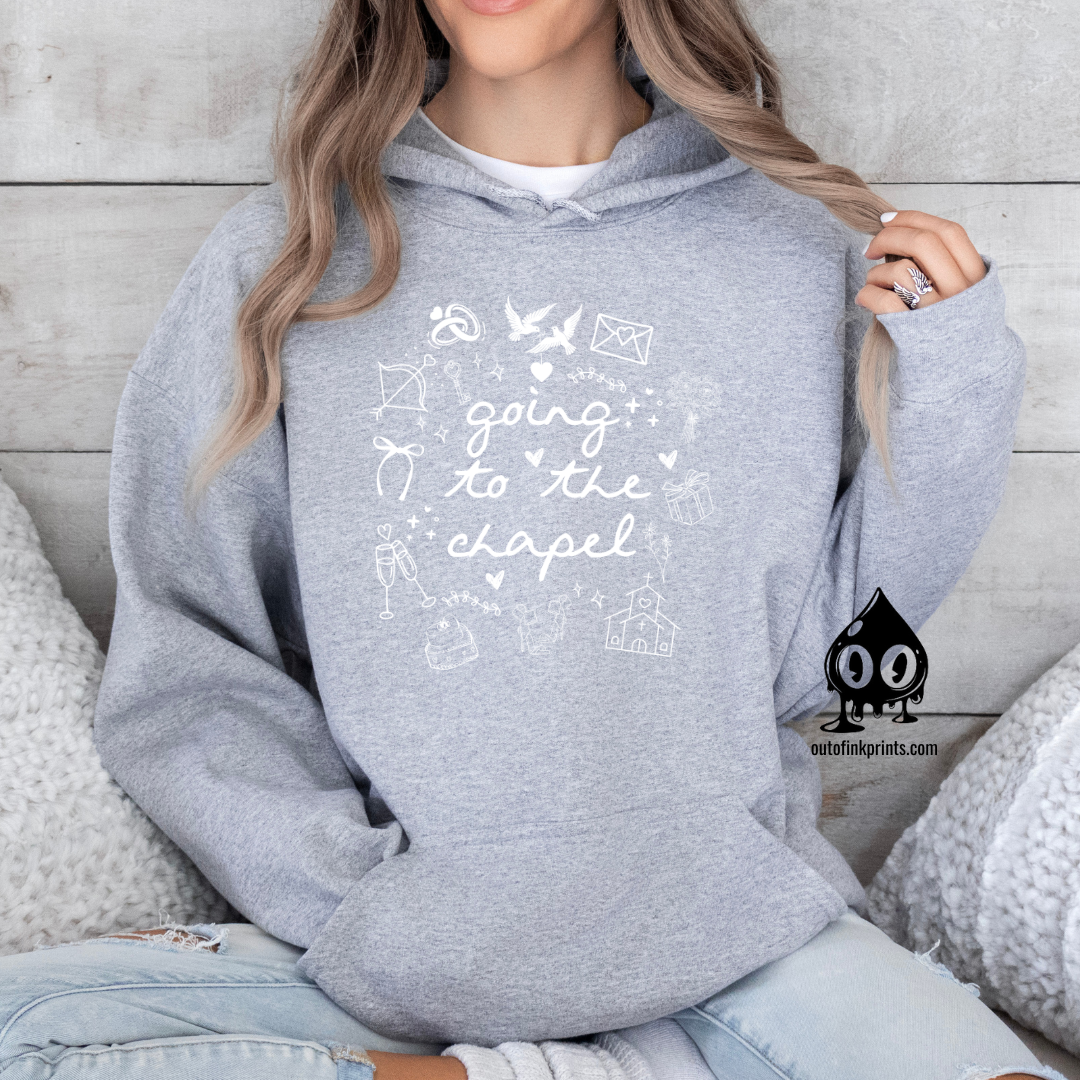 A woman wearing a gray hoodie with white text and graphics related to a bride and wedding chapel.
