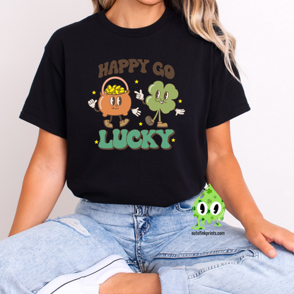 A person wearing a black 'Happy Go Lucky' t-shirt with cartoonish characters and text on it, suitable for St. Patrick's Day celebrations.