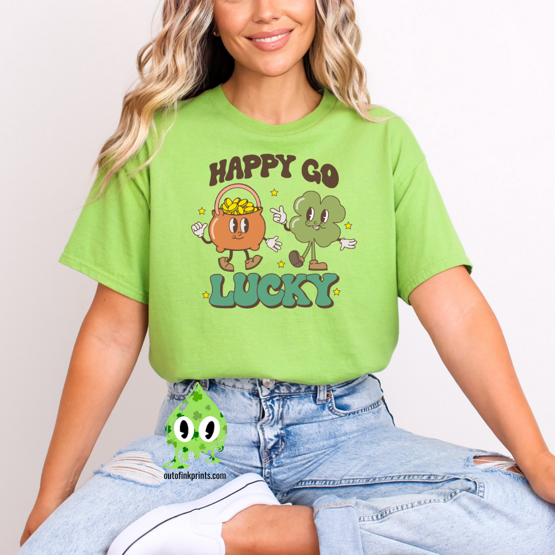 A person wearing a green 'Happy Go Lucky' t-shirt with cartoonish characters and text on it, suitable for St. Patrick's Day celebrations.