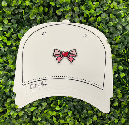 A Bow patch with a heart in the center on a white hat design