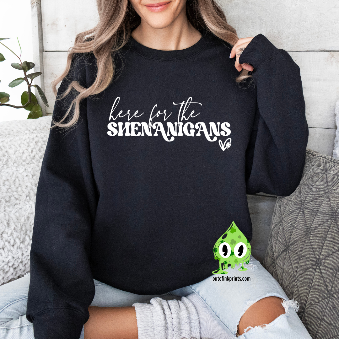 A woman wearing a black sweatshirt with the text 'here for the SHENANIGANS' printed on it.