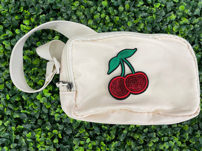  a Sequins cherry patch with a leafy backdrop and a white fanny pack