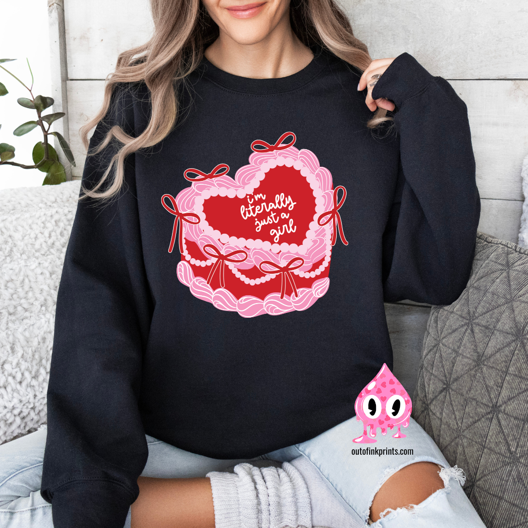 A woman sitting and wearing a black sweatshirt with a pink heart and text 'I'm Literally Just a Girl', alongside a graphic of a cake.