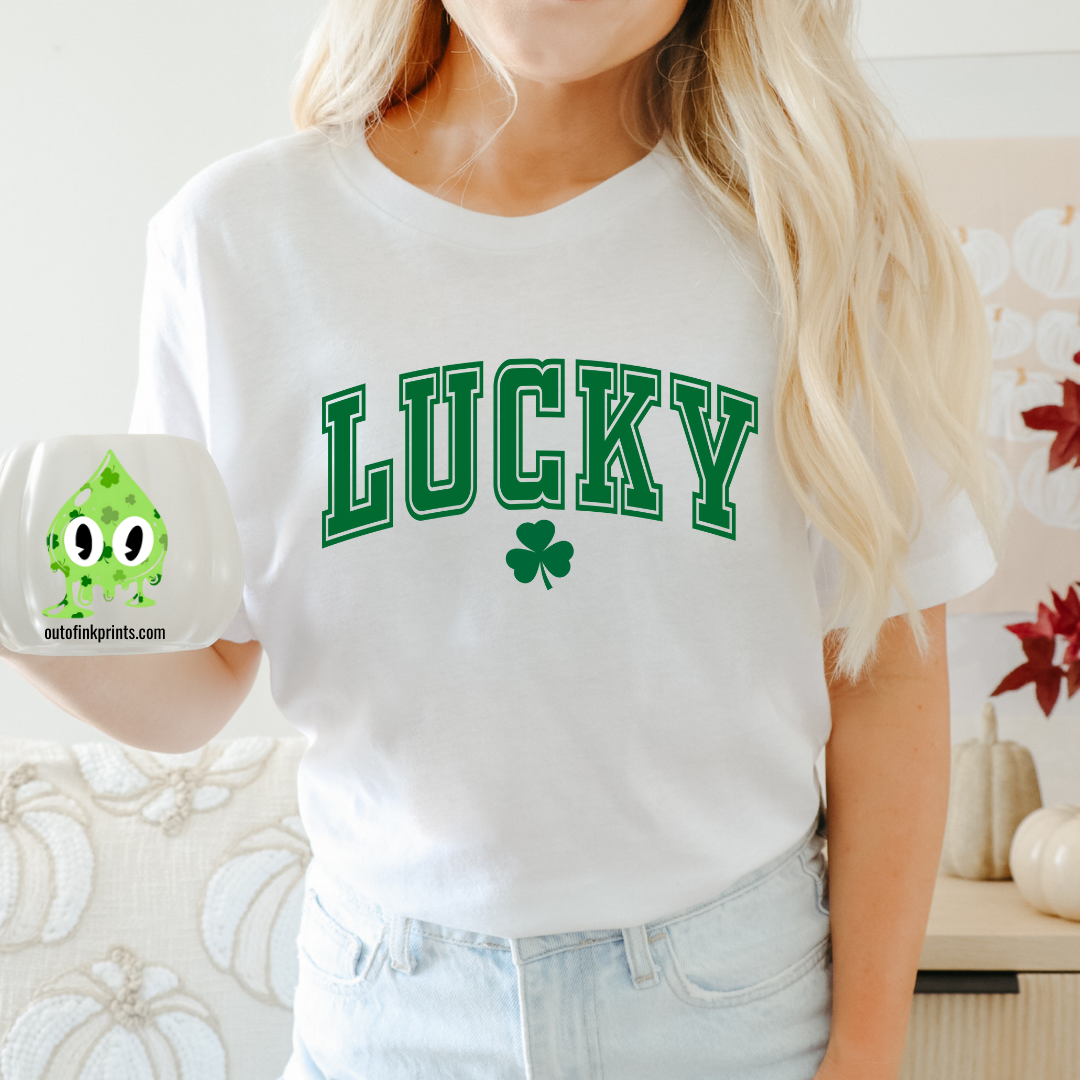 A woman wearing a white LUCKY Clover T-shirt with a shamrock graphic.