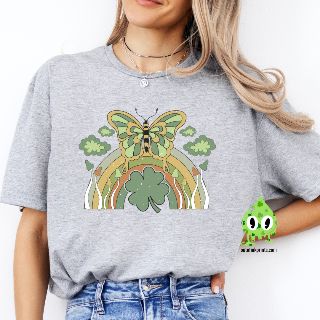 Front view of a gray t-shirt with a graphic design of a butterfly and rainbows, predominantly in green color, celebrating St. Patrick's Day.