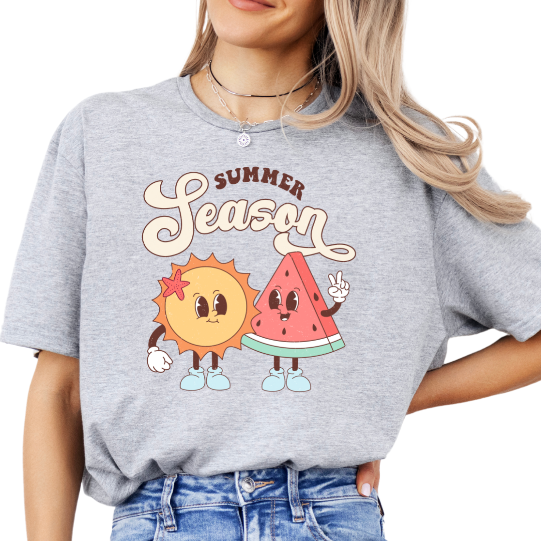 Front view of a grey t-shirt with a graphic print of a sun and a watermelon, and the text 'SUMMER SEASON'.