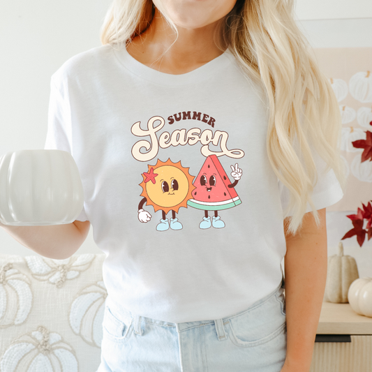 Front View of a white t-shirt with a graphic print of a sun and a watermelon, and the text 'SUMMER SEASON'.