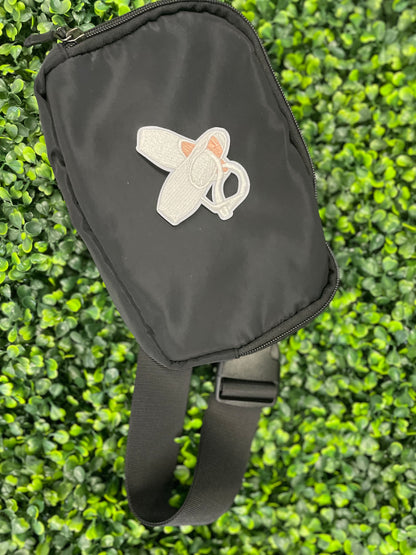 Embroidered patch of a pair of ballet slippers placed on a black shoulder bag