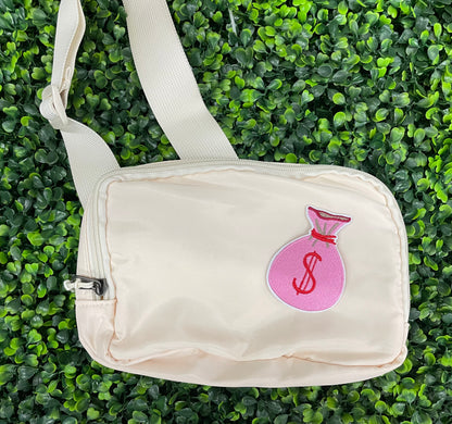 A patch depicting a pink bunched money bag with a red dollar sign, placed on a white shoulder bag