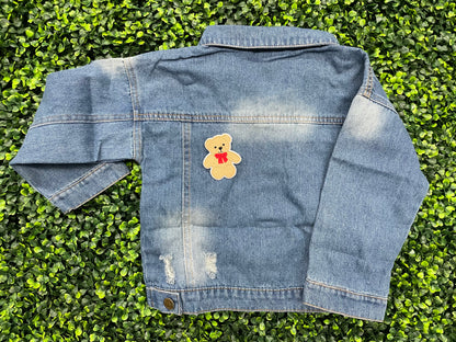 Embroidered Teddy Bear patch with a red bow set on the back of a child's jean jacket