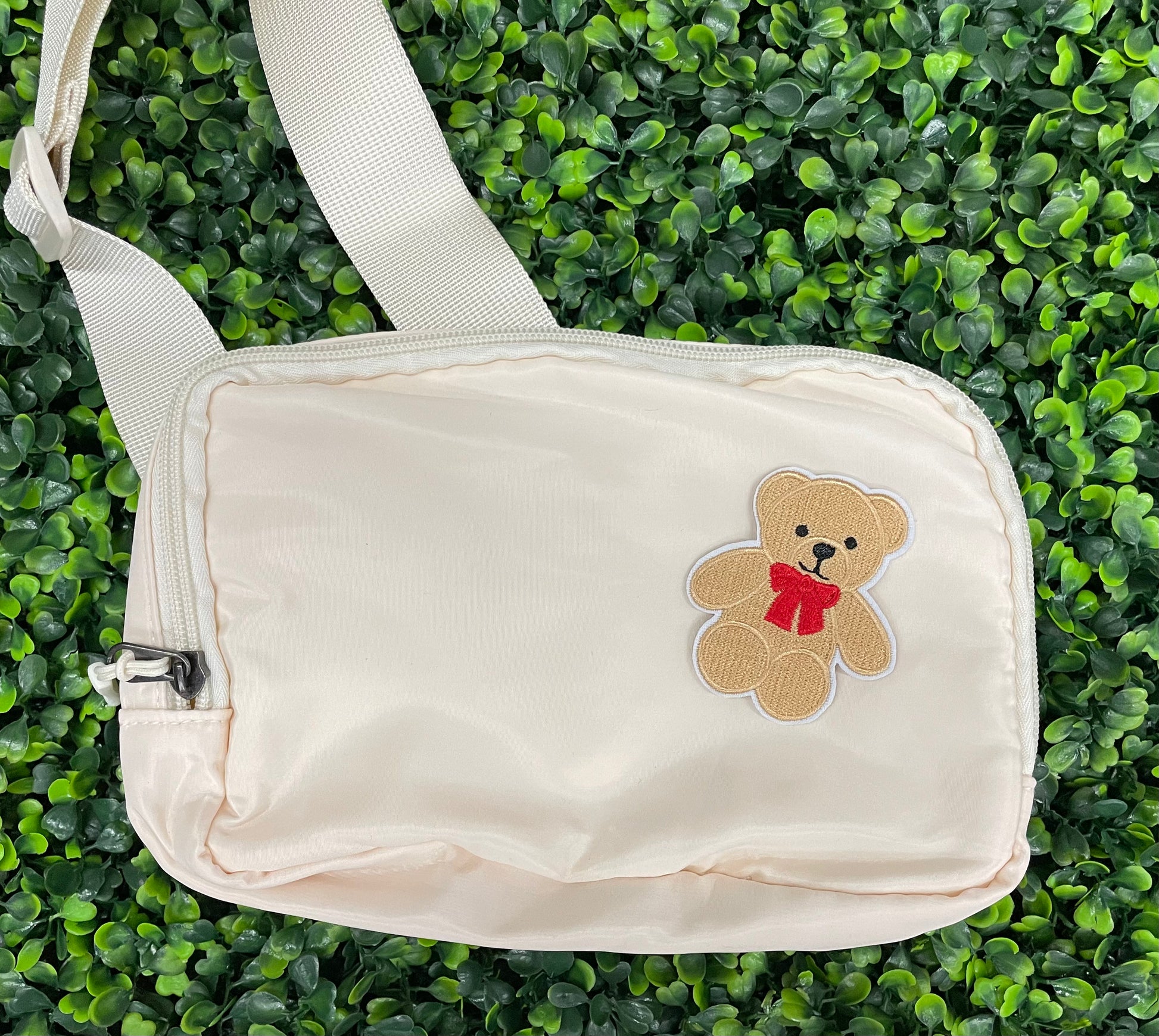 Embroidered Teddy Bear patch with a red bow set on a white bag